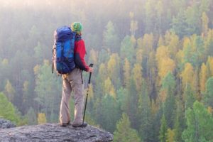 Man with backpack standing on a rock