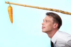 Businessman looking at a carrot on angle