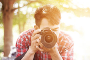 Photographer with camera focusing on subject