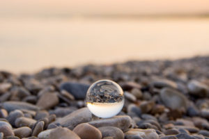 Glass marble on a pebbles beach