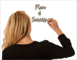 Woman writing "Plan 4 success" on a white board