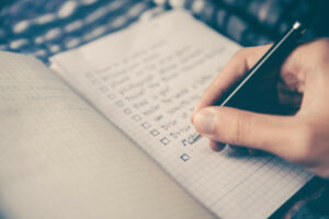 Writing a checklist in a notebook