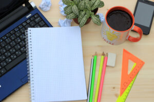 Laptop, notebook and pencils to write a one-page plan